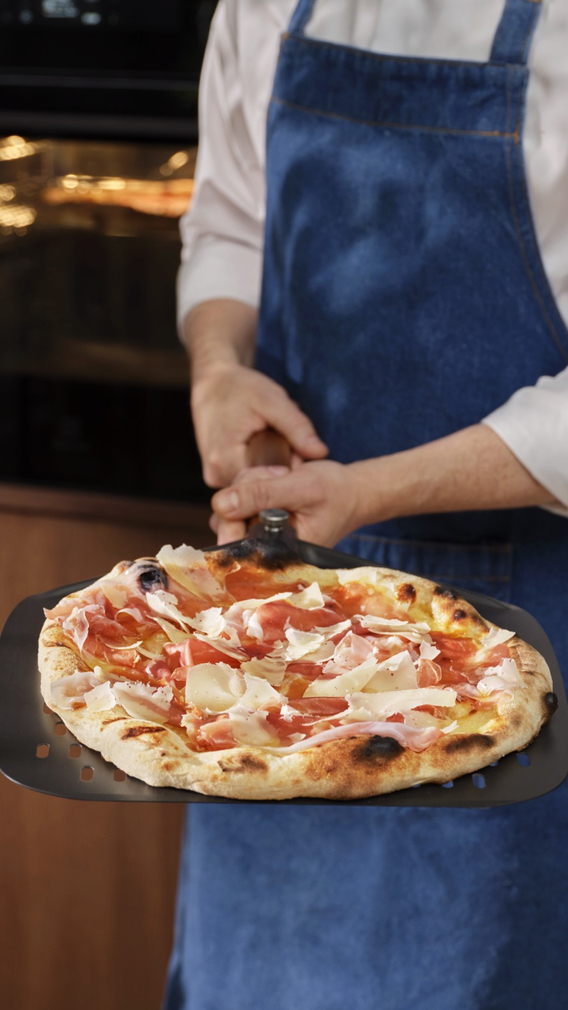 Muškarac drži pizzu.